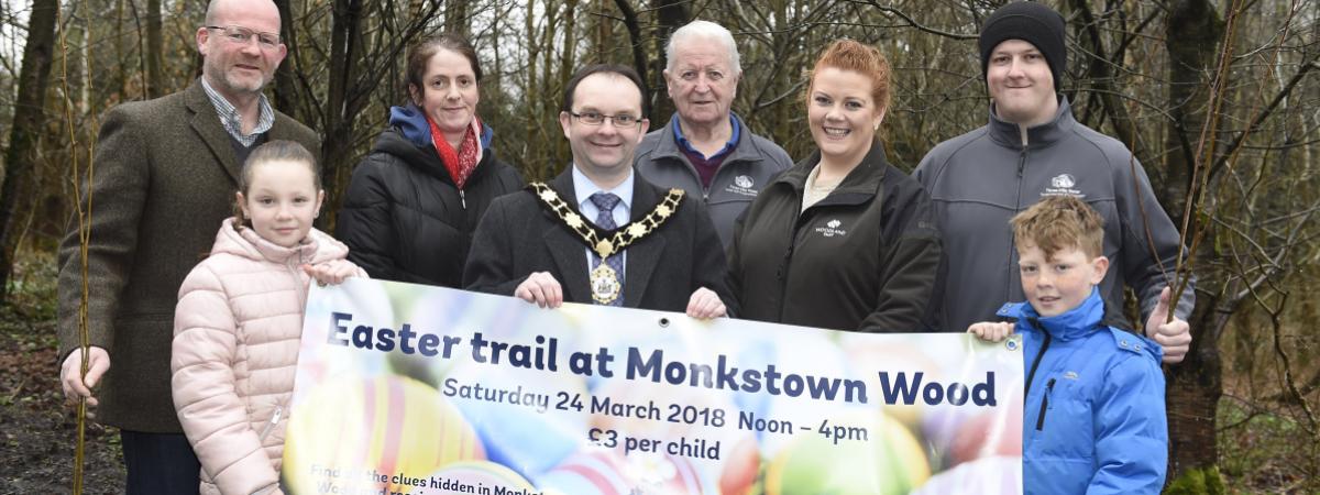 Funders and local people inspect the site improvements at Monkstown Wood.  They are pictured holding up an 'Easter Trail' banner.