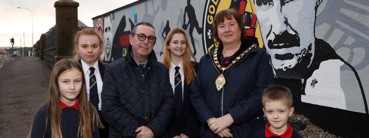 Dave ‘Boy’ McCauley and Mid and East Antrim Mayor, Cllr Maureen Morrow alongside pupils from Moyle Primary School and Larne High School reveal the new mural.