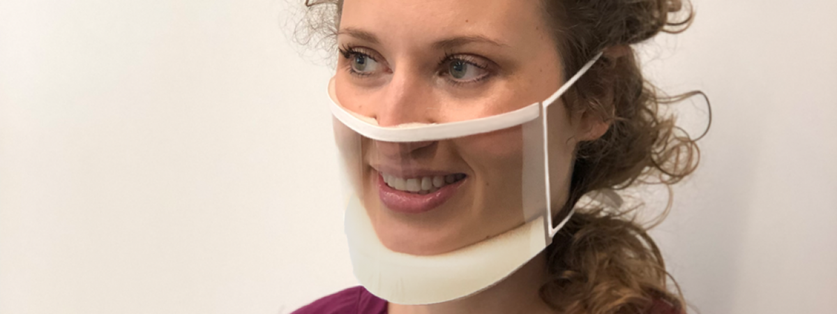 woman wearing a clear mask and smiling