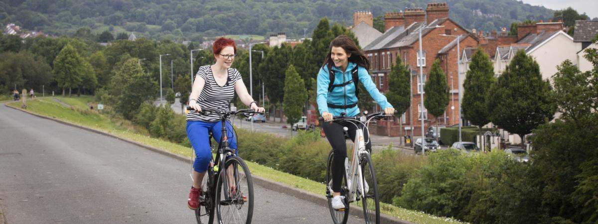 Two women cycling in a park in North Belfast