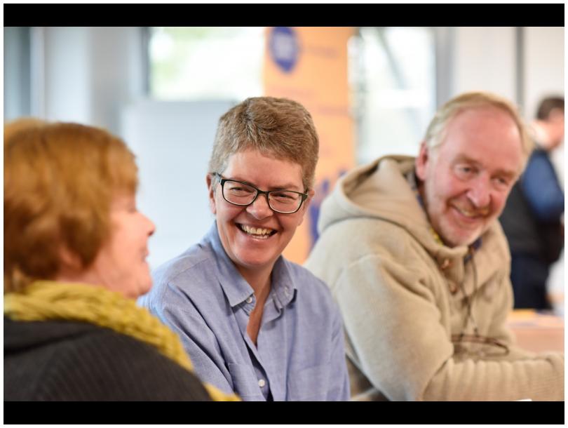 Three people sitting laughing together