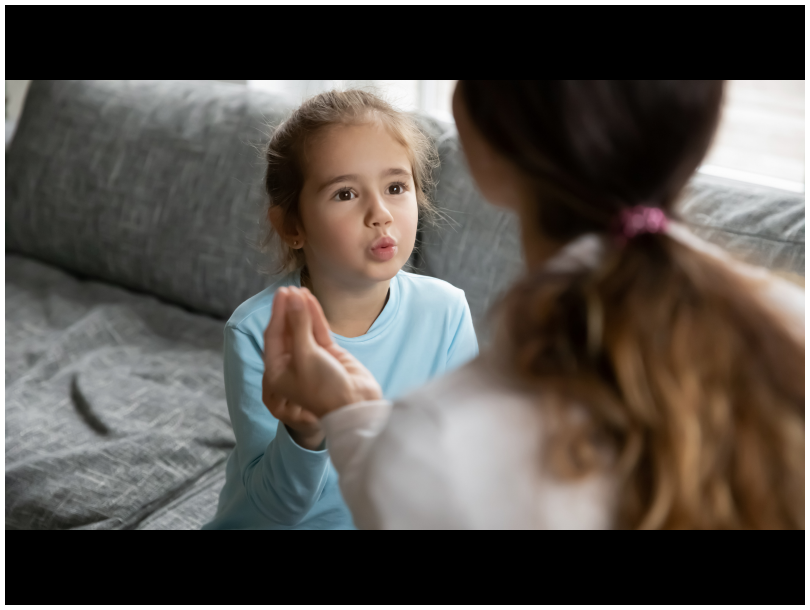 Young girl being taught at home by young woman