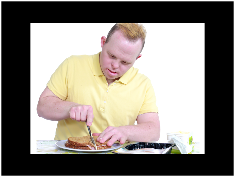 Picture of a man with down syndrome making a sandwich.