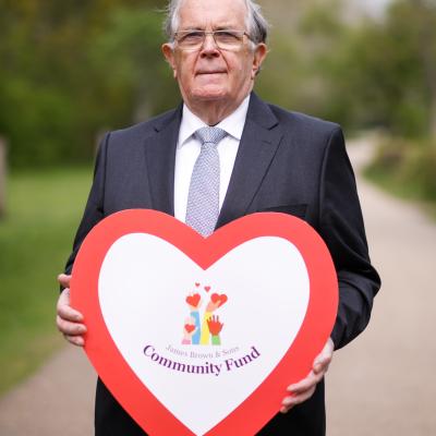 James Brown from James Brown & Sons holding a signs saying James Brown & Sons Community Fund