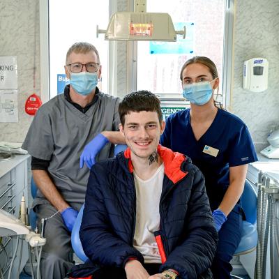 Pictured at the launch of a mobile dental health clinic provided by Dentaid The Dental Charity and staffed by volunteers from Bupa Dental Care to provide oral health care for people supported by Simon Community NI are clinician Paul Blundell, patient Curtis and clinician Teona Baillie. The clinic will offer free emergency care and dental health advice at Simon Community sites in Belfast, Bangor and Armagh every month for the rest of the year. 