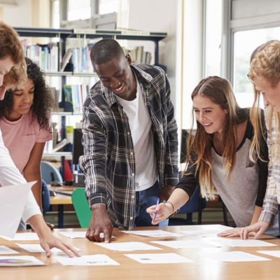 Young people standing at a desk working together on a project.